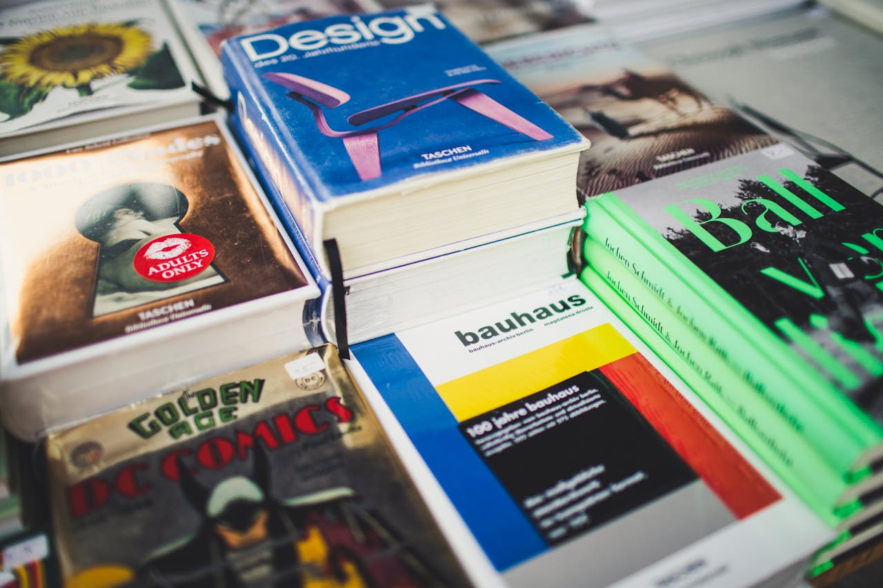 hero-img-01 A colorful array of books on design and literature, perfect for art lovers and comic enthusiasts.